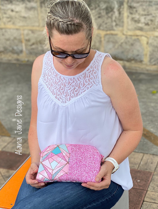 Action shot of the pink and sparkly Gemma Carryall Pouch - Andrie Designs