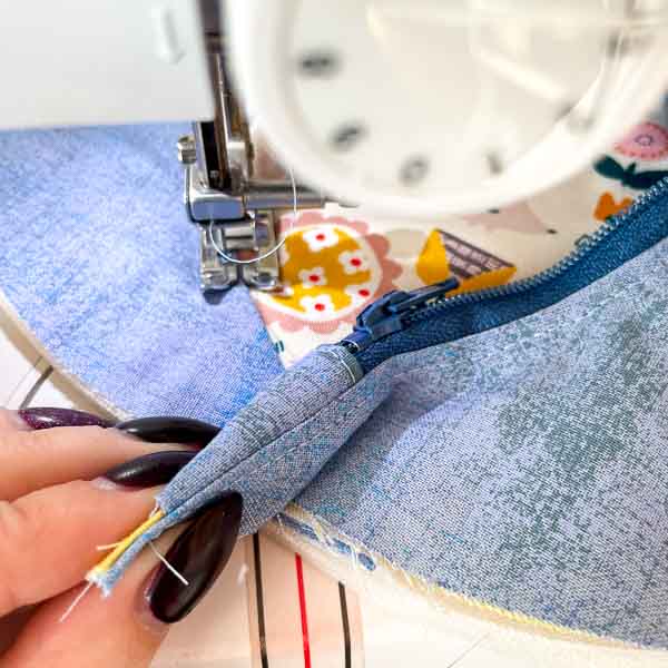 Sew to zipper tab, lifting to sew slightly under it - Peekaboo Pocket Hack - Andrie Designs